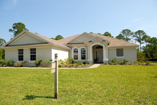 House with a FOR SALE sign on the lawn