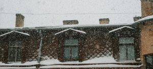 The roof of a building during a snowstorm, which endured because of adequate roof maintenance in extreme weather conditions.