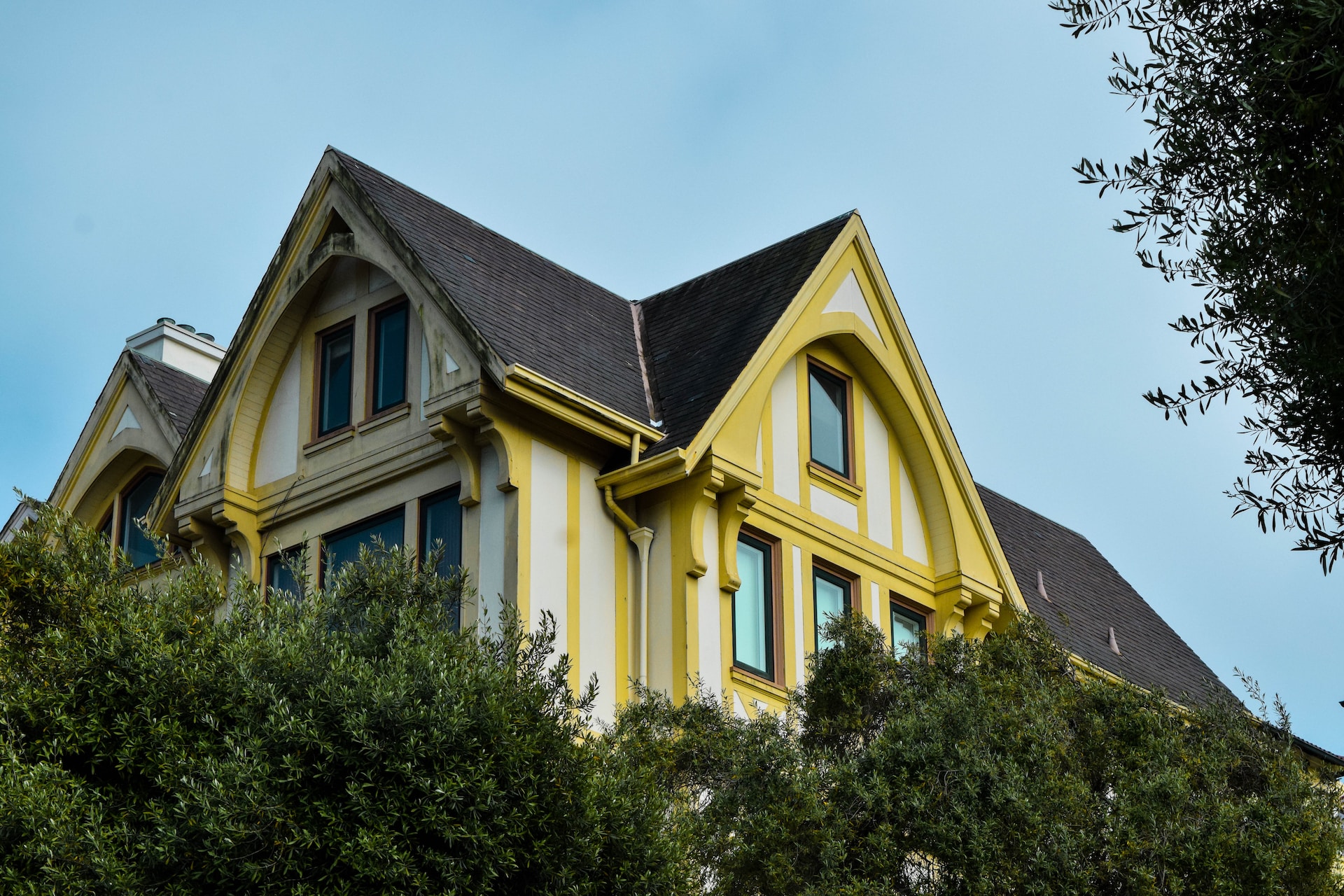 A yellow house that shows off the aesthetic impact of roof design