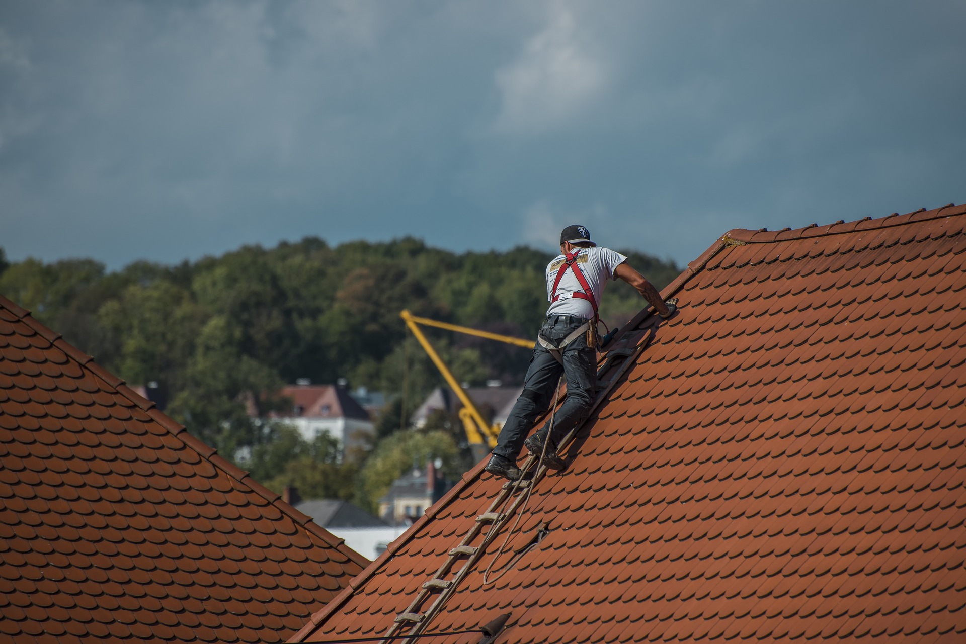 A hired contractor working on long-term roof maintenance while you’re abroad