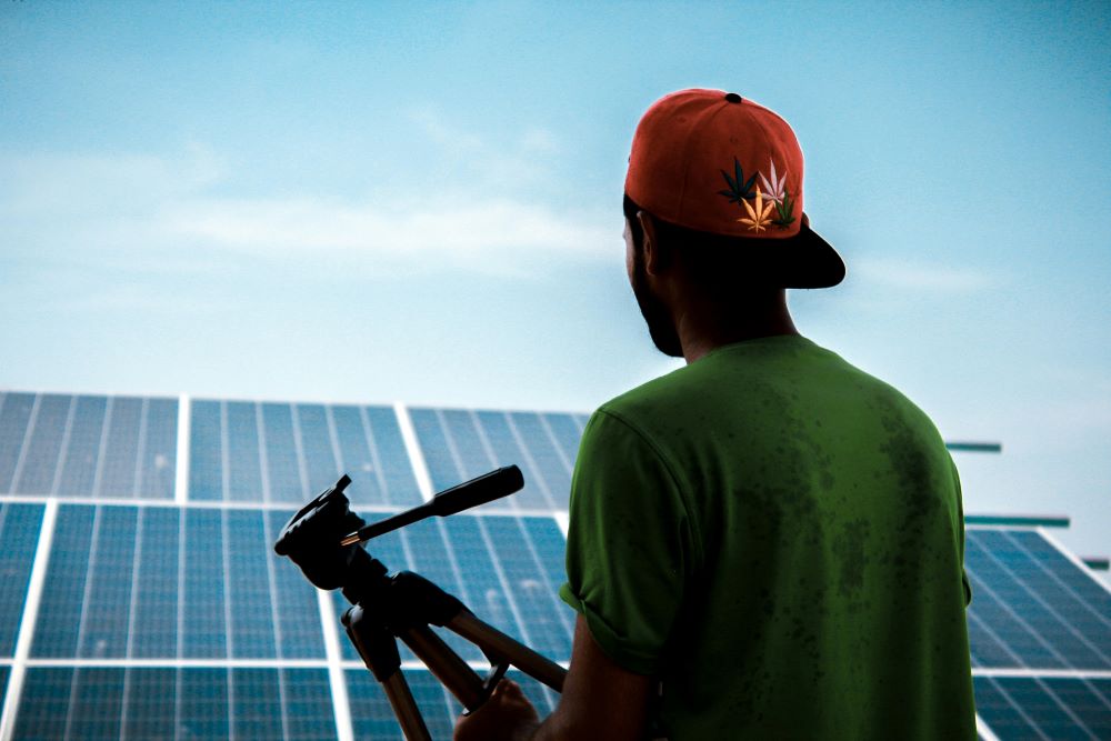 a person with a camera looking at solar panels