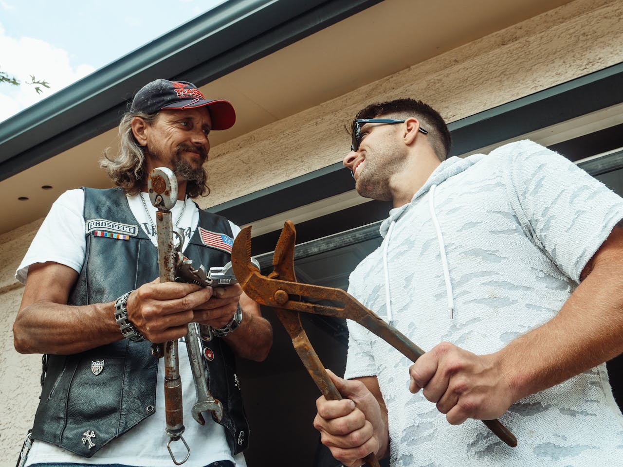 Men holding rusty tools.